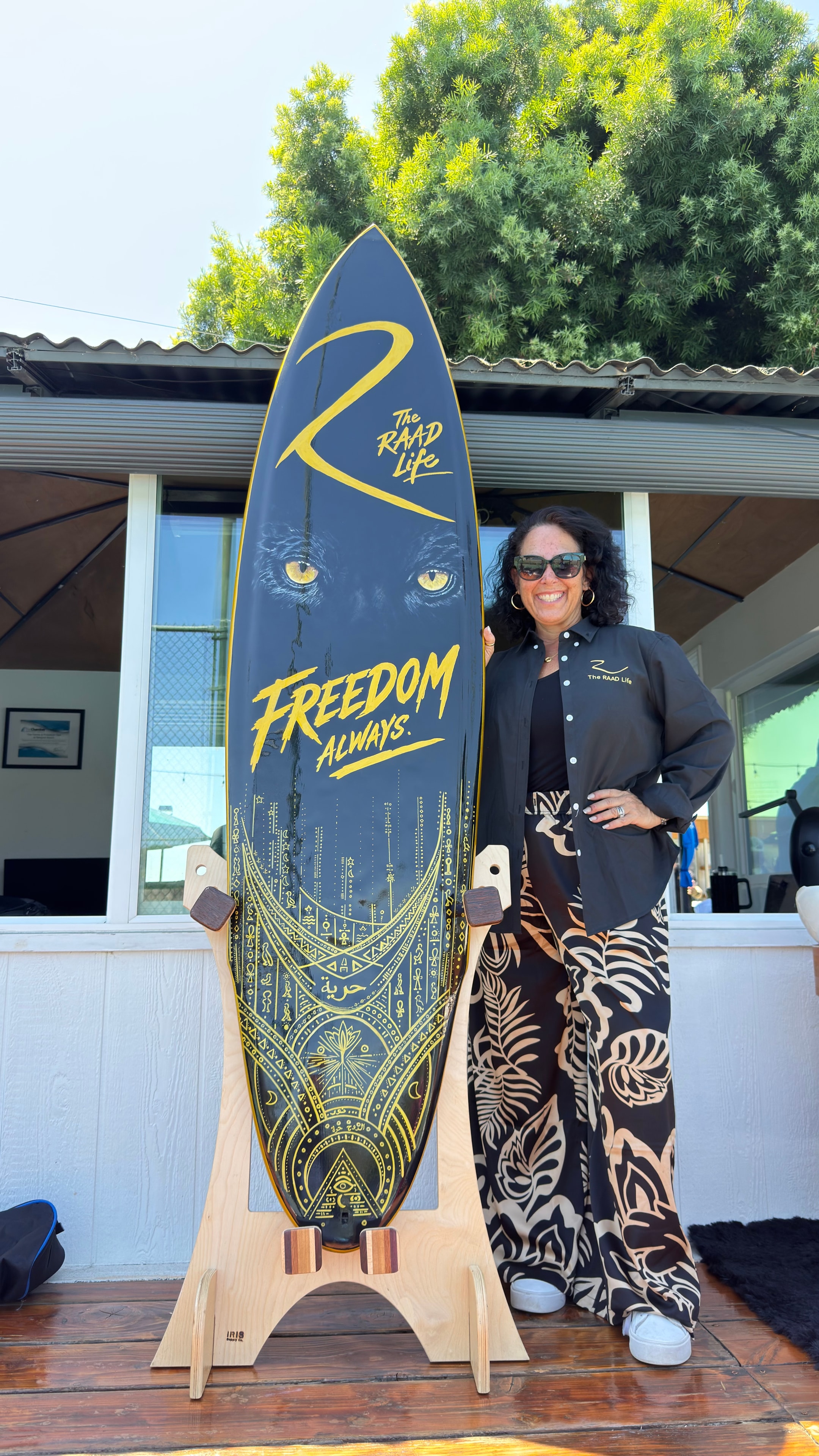 Shannon Ratcliffe posing with her hand-painted surfboard artwork