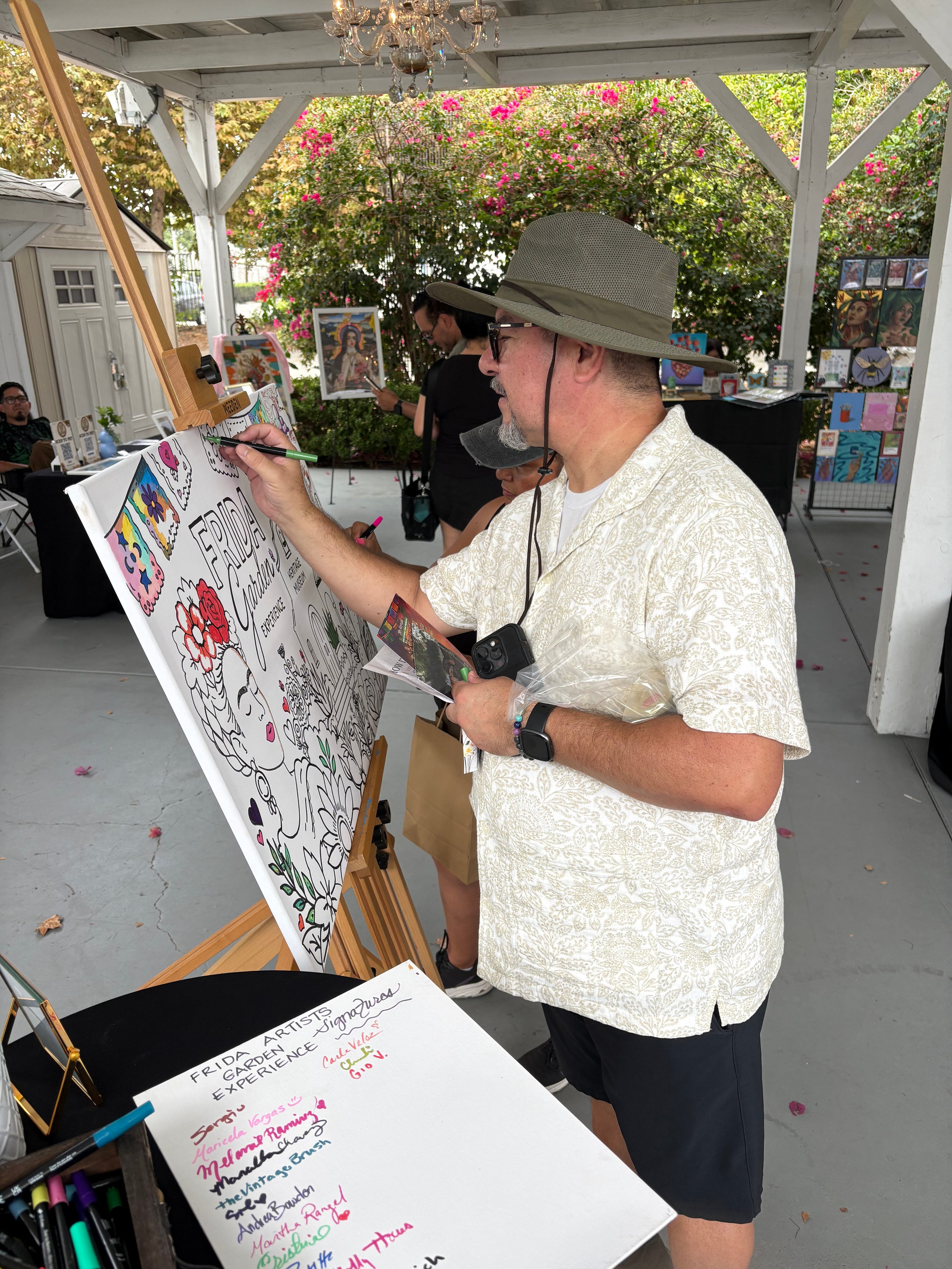 Artist drawing on large collaborative canvas at Shannon Paints event